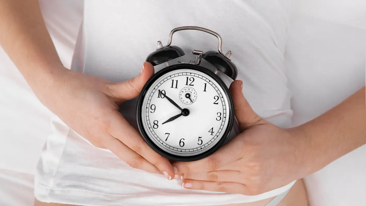 mujer sosteniendo reloj sobre su vientre