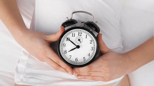 mujer sosteniendo reloj sobre su vientre