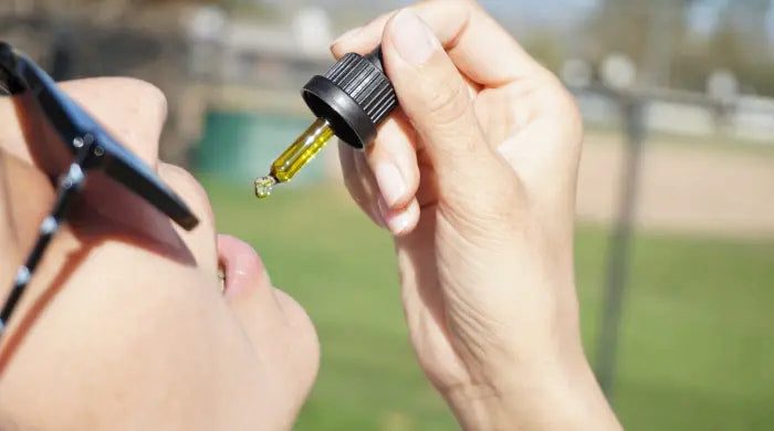 ¿Es adictivo el CBD? En esta imagen un persona consume CBD desde un gotero